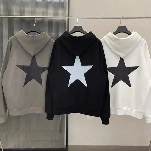Men's star print long sleeve hoodies in gray, black, and white hanging on a rack.
